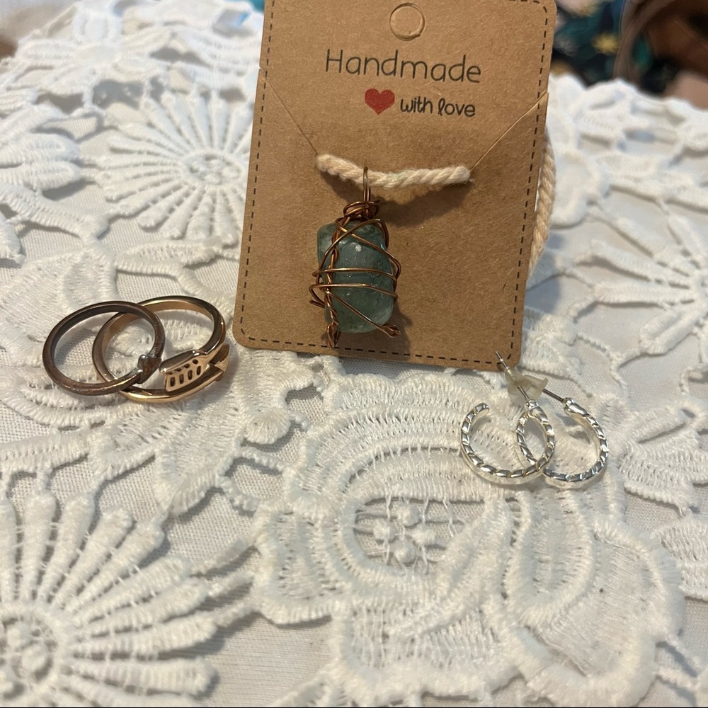 Two rings one pair of earrings and a rock necklace.
